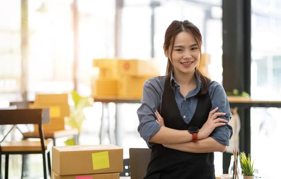 Portrait of Asian young woman SME working with a box at home the workplace.start-up small business owner, small business entrepreneur SME or freelance business online and delivery concept..