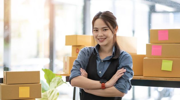 Portrait of Asian young woman SME working with a box at home the workplace.start-up small business owner, small business entrepreneur SME or freelance business online and delivery concept..