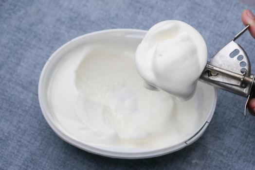 hand picking ice cream with a spoon from a bowl .