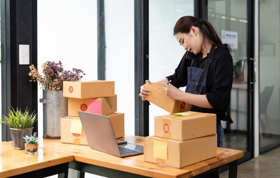 Business woman owner with parcel box for delivery and call phone. Entrepreneur small business working at home