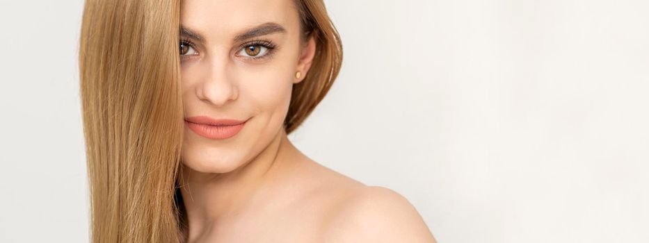 Beautiful caucasian young woman with one tulip against a white background