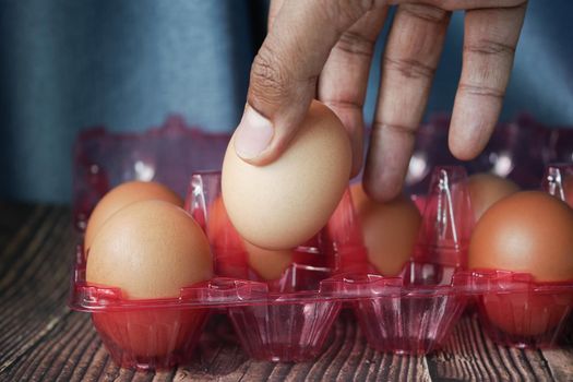 hand pick eggs from a plastic case on table ,