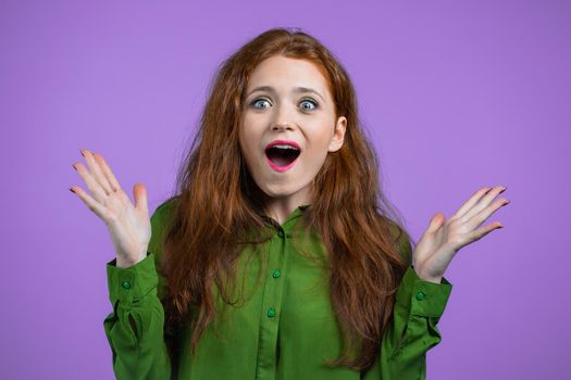 Young woman is very glad, she screaming wow loud. Concept of sales, profitable offer. Excited happy lady on violet studio background. High quality photo