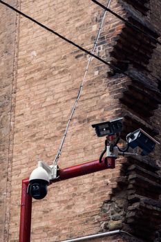 Day view of CCTV security surveillance digital observation cameras on a pole above a public street.