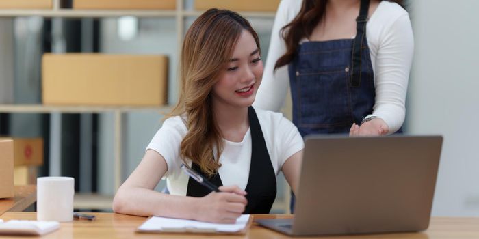 Asian SME business woman with partner working at home office. online shopping concept.