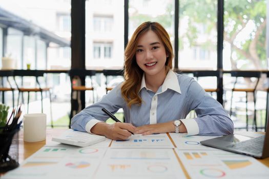 Modern asian business woman analysis financial paperwork document.