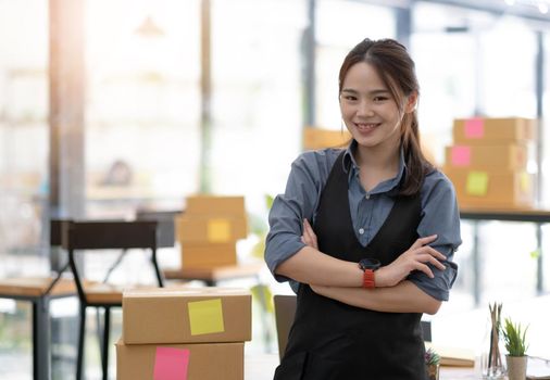 Portrait of Asian young woman SME working with a box at home the workplace.start-up small business owner, small business entrepreneur SME or freelance business online and delivery concept..