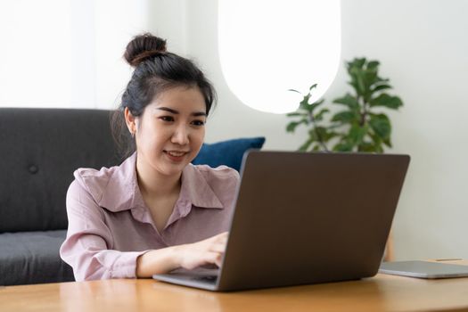 Asian woman freelance working with laptop computer at home