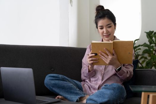 Asian young female using laptop listen and learning online courses at home