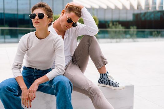 Young couple having problems in their relationship. man and woman friends in sunglasses sitting bench in city unhappy emotions. Relationships problem.