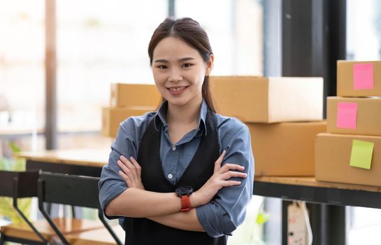 Portrait of Asian young woman SME working with a box at home the workplace.start-up small business owner, small business entrepreneur SME or freelance business online and delivery concept..