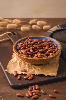 Red beans in a ceramic bowl on a rustic kitchen countertop.