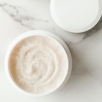 Scrub and exfoliating cream products on a marble, flatlay - skincare and body care, luxury spa and clean cosmetic concept. Health and beauty of your skin
