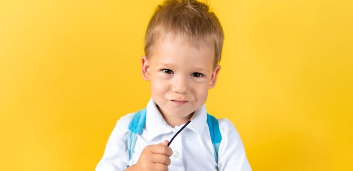 Banner Funny Preschool Child Boy smiles and looks slyly at camera on Yellow Background Copy Space. Happy Smiling Kid Go Back to School, Kindergarten. Success, Motivation, Genius, Superhero concept.