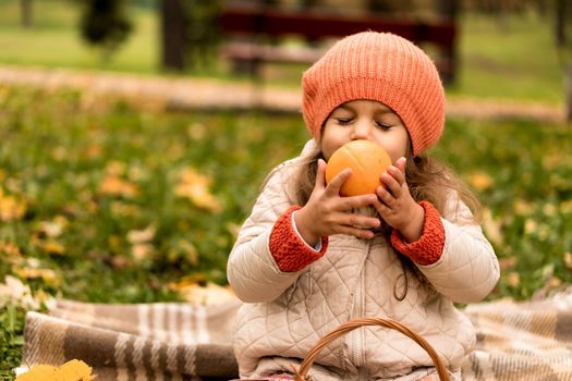 Little Cute Preschool Minor Baby Girl In Beret On Plaid Sniffs Orange Yellow Fallen Leaves In Basket Nice Smiling Close Eyes At Cold Weather In Fall Park. Childhood, Family, Motherhood, Autumn Concept.