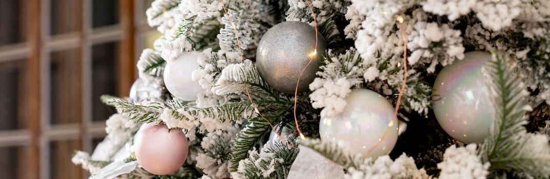 Christmas texture of white delicate Christmas tree and Christmas decorations, balls and ribbons, garland and lights.