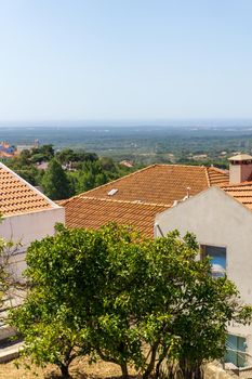 View of white houses with red tiled roofs in a Portuguese town on a sunny day