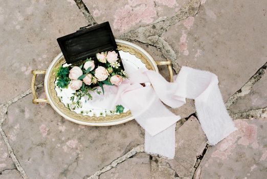 Tray with roses lies on a tile on the floor. High quality photo