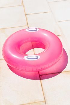 Translucent pink swim ring under the bright sun background