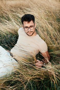 Portrait of a young man fashion model outdoors in the field