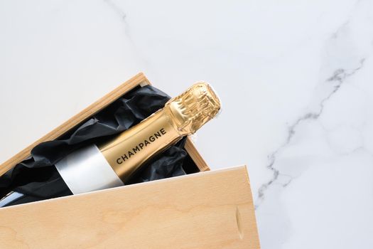 Wedding celebration, lifestyle and luxury present concept - A champagne bottle and a gift box on marble