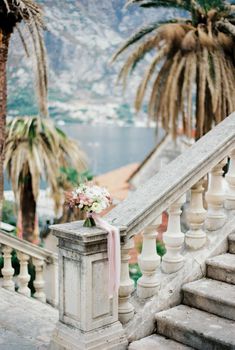 Wedding bouquet stands on a balustrade overlooking the sea and mountains. High quality photo