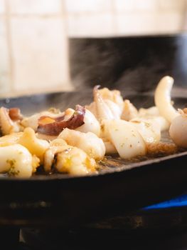 grilling a raw adriatic cuttlefish at home in Numana, Marche, Italy