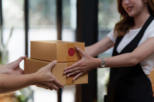 Asian woman employee freelance with parcel box for delivery to customer.