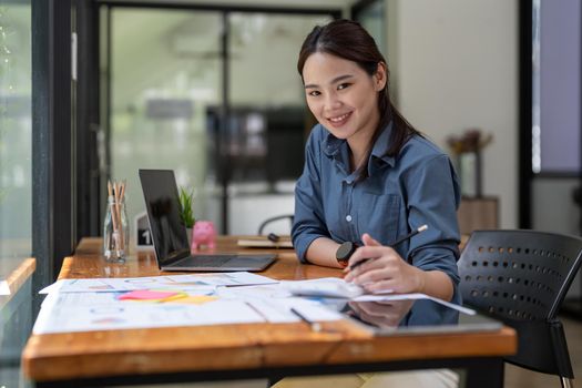 Portrait asian accountant or auditor working with calculator and laptop computer