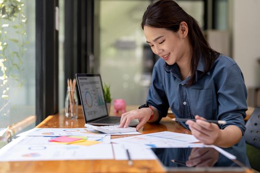 businesswoman working on desk office with using a calculator to calculate the numbers, finance accounting concept.