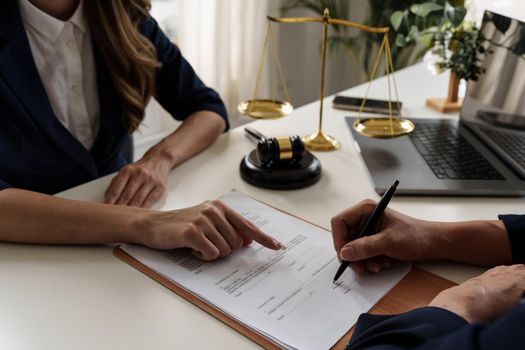 Business woman and lawyers discussing contract papers with brass scale on wooden desk in office. Law, legal services, advice, Justice concept.