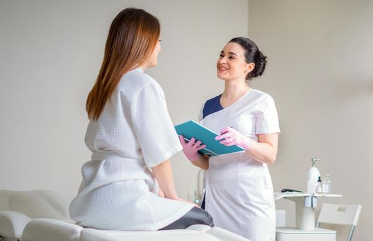 Female Patient And Doctor Have Consultation during appointment In modern medical clinic