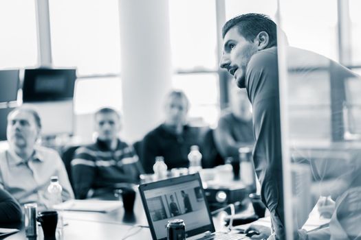 Business man making a presentation at office. Business executive delivering a presentation to his colleagues during meeting or in-house business training, explaining business plans to his employees.