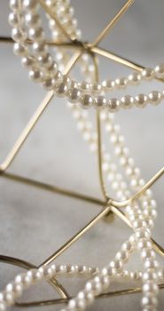 Pearl necklace on golden marble, ethical jewellery - luxury background, jewelry as a gift concept. Pearls are girl's best friends