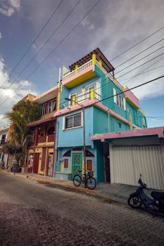 Isla Mujeres, Mexico 20 august 2022: Street view of a neighborhood of Isla Mujeres in Mexico: You can see the palaces and the colored houses that form the urbanism of this beautiful Caribbean island. Vertical Shot.