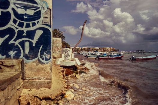Playa del carmen, Mexico 20 august 2022: View of the Playa del Carmen pier filtered by a wall with graffiti during a summer afternoon.