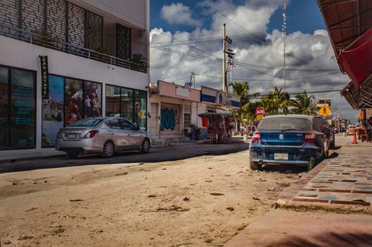 Tulum, Mexico 20 august 2022: View of a street of Tulum in Mexico with unpaved roads and some vehicles parked at the side