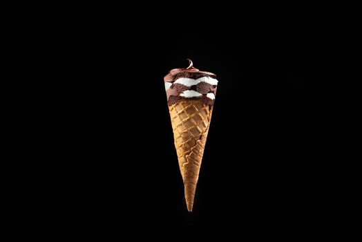 Chocolate ice cream in a waffle cone on a black background isolate