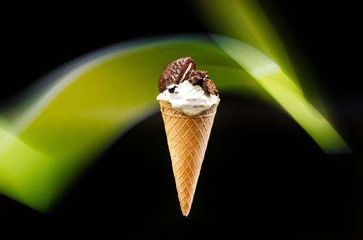 Homemade Cookies and cream cone ice cream, on a dark background with an abstract green line in the background.