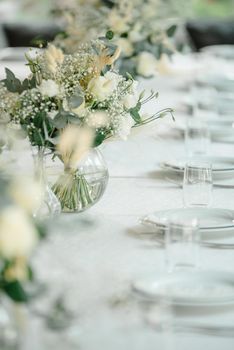 Wedding reception table in the restaurant decorated with white candles and flowers