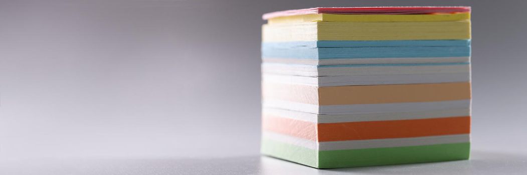 Close-up of perfect stack of colourful paper for notes, set of sticky post it notes. Bright office pages for reminder or ideas writing. Stationery concept