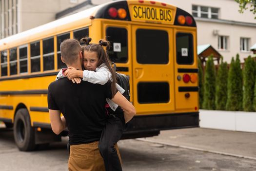 Parent taking child to school. Pupil of primary school go study with backpack outdoors. Father and son go hand in hand. Beginning of lessons. Back to school. First day of fall. Elementary student.