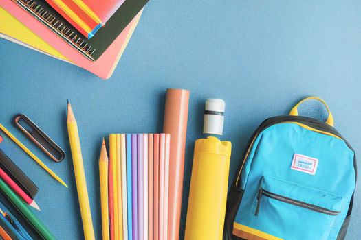 Backpack with various colorful stationery on a table of school supplies against a black background, back to school concept. 3D illustration