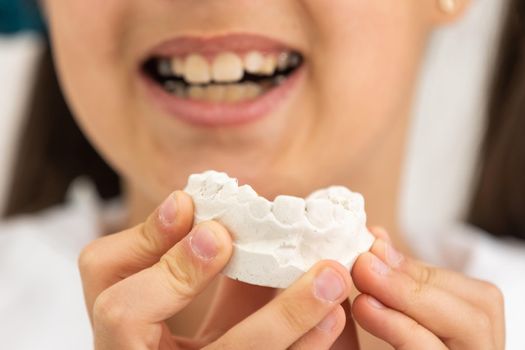 little girl with plaster cast of teeth and with the metal apparatus on the teeth