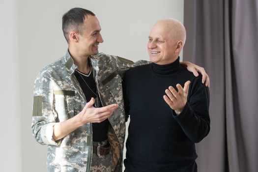 Father and son in camouflage. Concept of father's day, father's return home