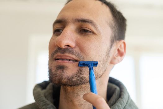 Time for new razor. Closeup of a razor on his chin stubbly