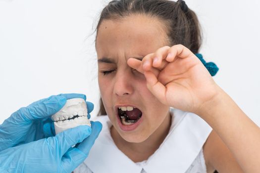 little girl with plaster cast of teeth and with the metal apparatus on the teeth