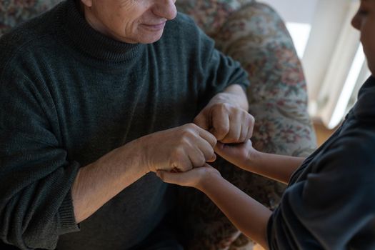 grandfather and granddaughter hands close up.