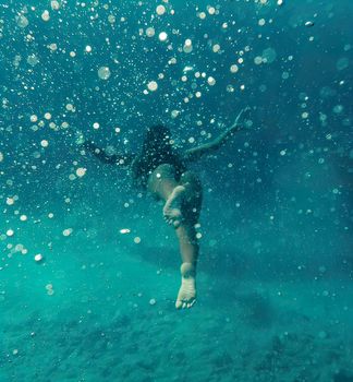 Beautiful girl. Girl under the water of the red sea. A girl is floating in the red sea. High quality photo