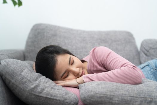 Young asian woman sleeping on sofa at home.
